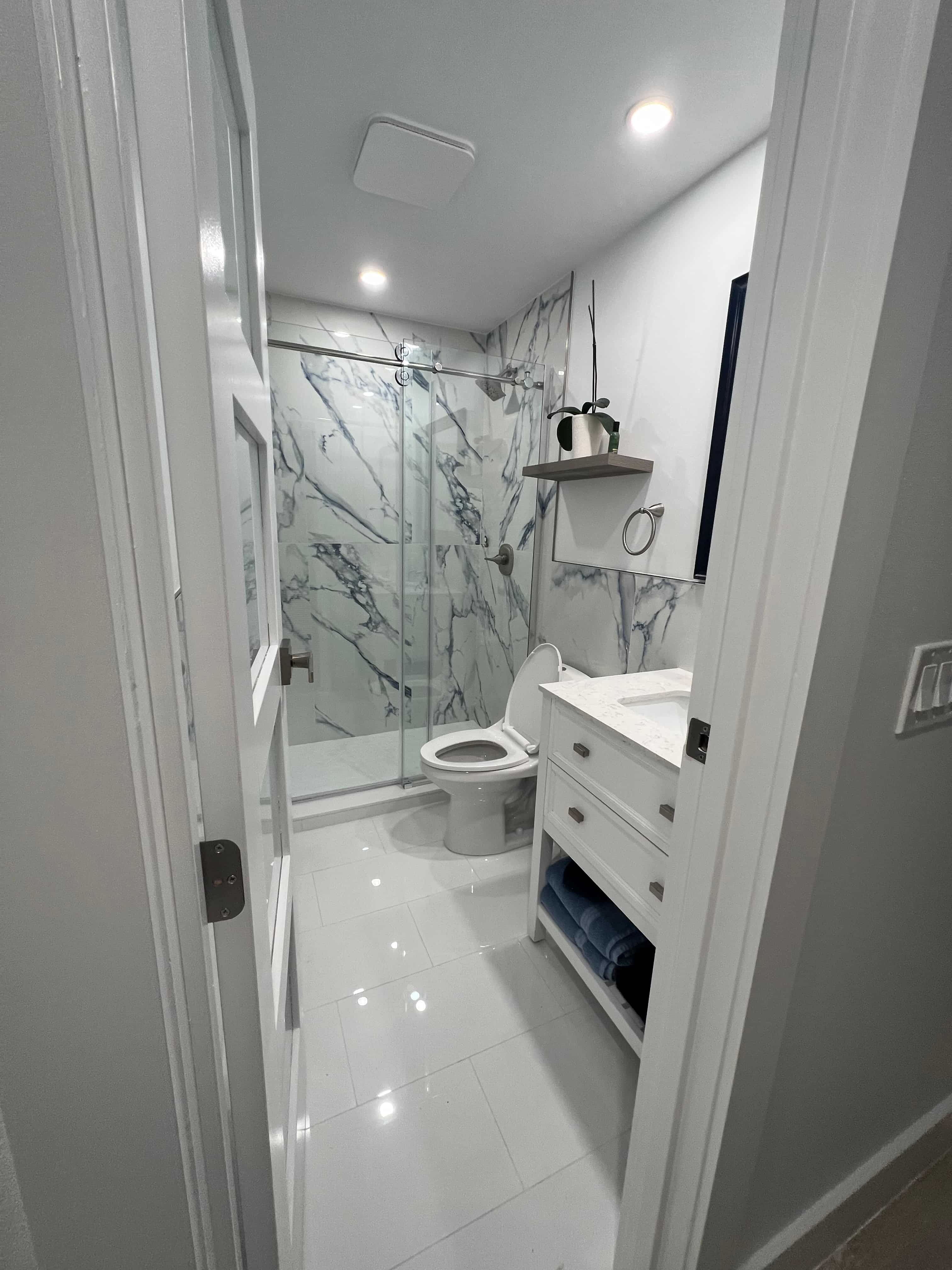 Finished GRV bathroom remodel in Vero Beach — new vanity and marble-look shower tile