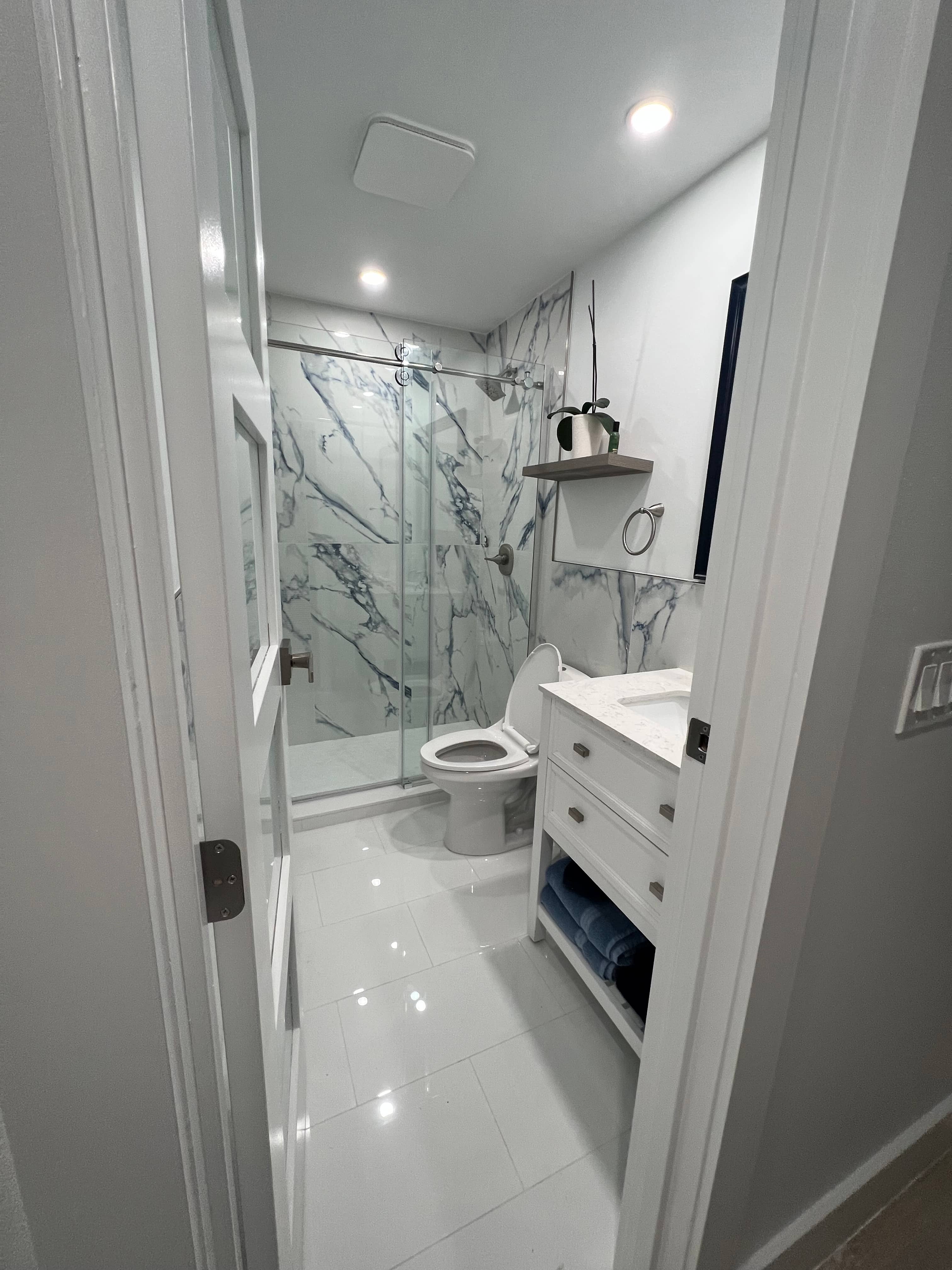 Finished GRV bathroom remodel in Vero Beach — new vanity, marble-look shower tile