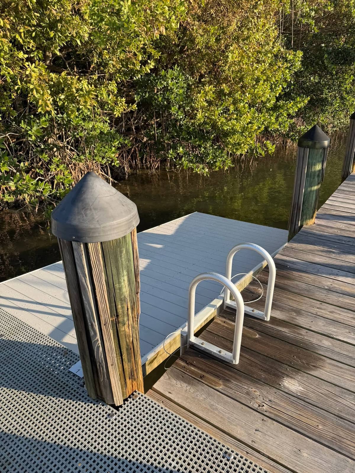 Finished GRV floating boat dock with composite decking on a mangrove shoreline