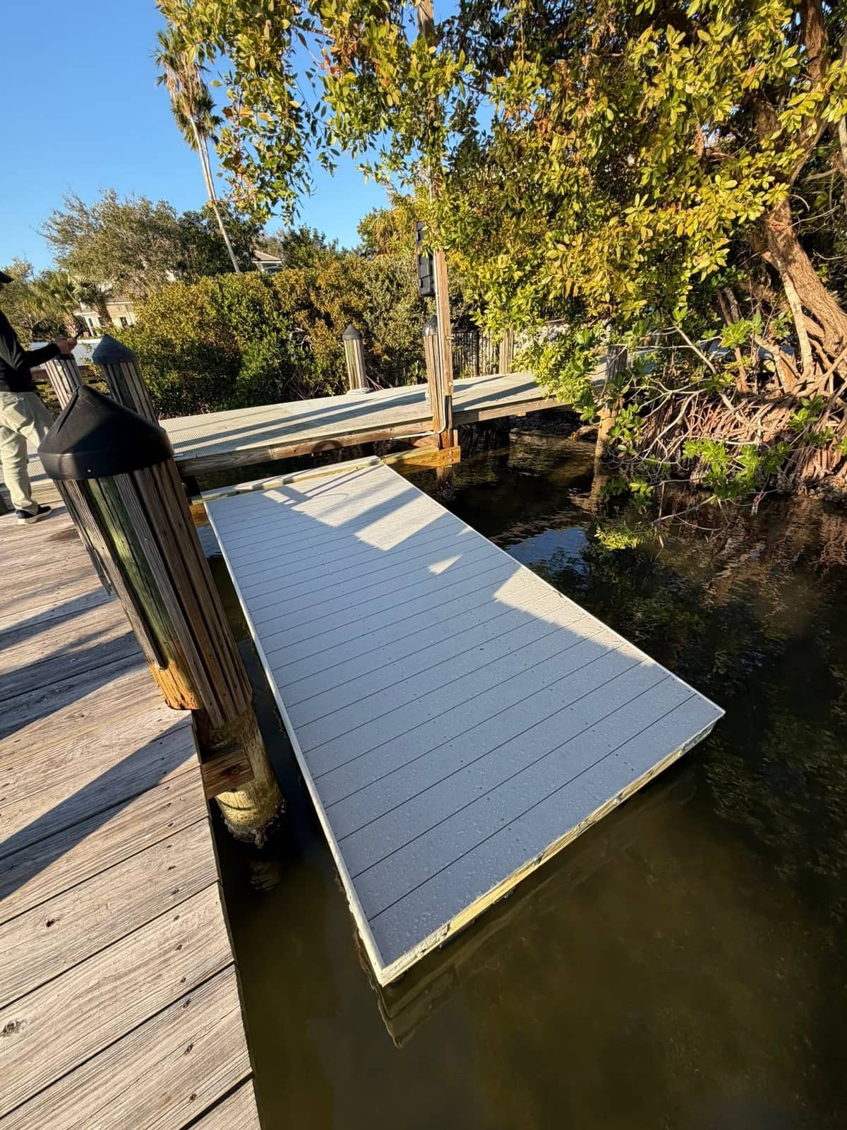GRV floating dock connecting to a fixed pier under mangrove canopy